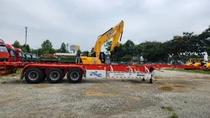 Sơ mi rơ mooc cổ cò 50ft mầu đỏ cạnh máy xúc đào jcb